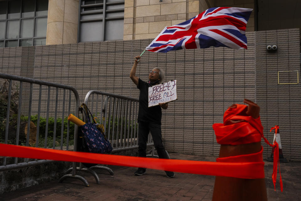 A pro-democracy activist known as "Grandma Wong" protests outside the West Kowloon courts in a cordoned off area set up by police as closing arguments open in Hong Kong's largest national security trial of 47 pro-democracy figures in Hong Kong, Wednesday, Nov. 29, 2023. (AP Photo/Louise Delmotte)