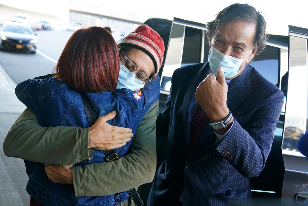 Danny Fenster, center, hugs his mother Rose Fenster as former U.S. diplomat Bill Richardson, right, looks on at John F. Kennedy Airport in New York, Tuesday, Nov. 16, 2021. Fenster was sentenced last week to 11 years of hard labor. He was handed over Monday to Richardson, who helped negotiate the release. (AP Photo/Seth Wenig)