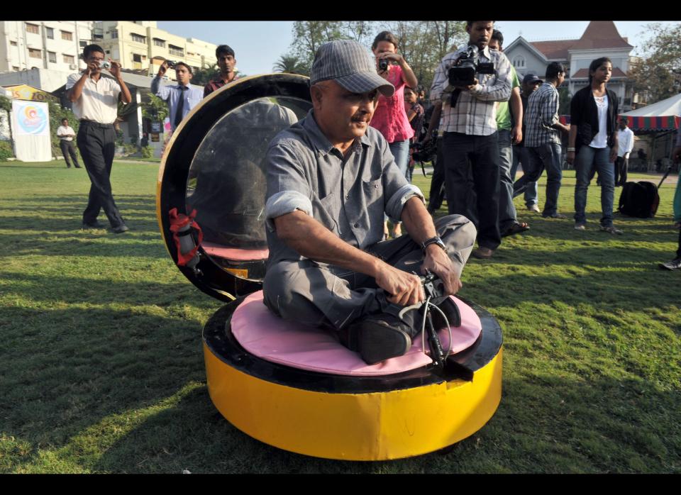 Indian wacky car designer Sudhakar Yadav sits inside a vehicle made in the shape of a makeup compact. Yadav has made more than 30 quirky vehicles and hopes to eventually make 100.
