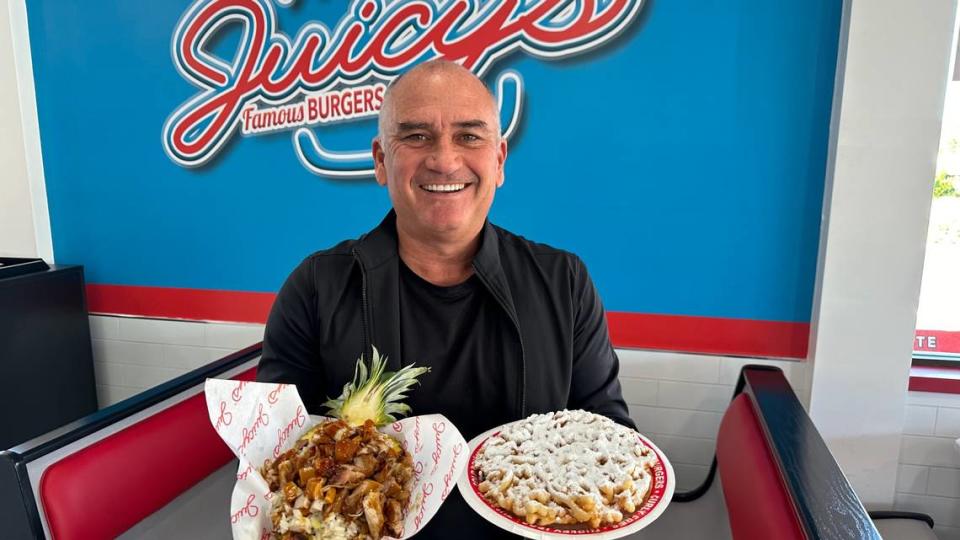 Brett Enright shows a teriyaki chicken pineapple bowl and a funnel cake 11/29/2023 at Juicys​ Famous Fair Food, 2319 Cortez Road W., Bradenton. James A. Jones Jr./jajones1@bradenton.com