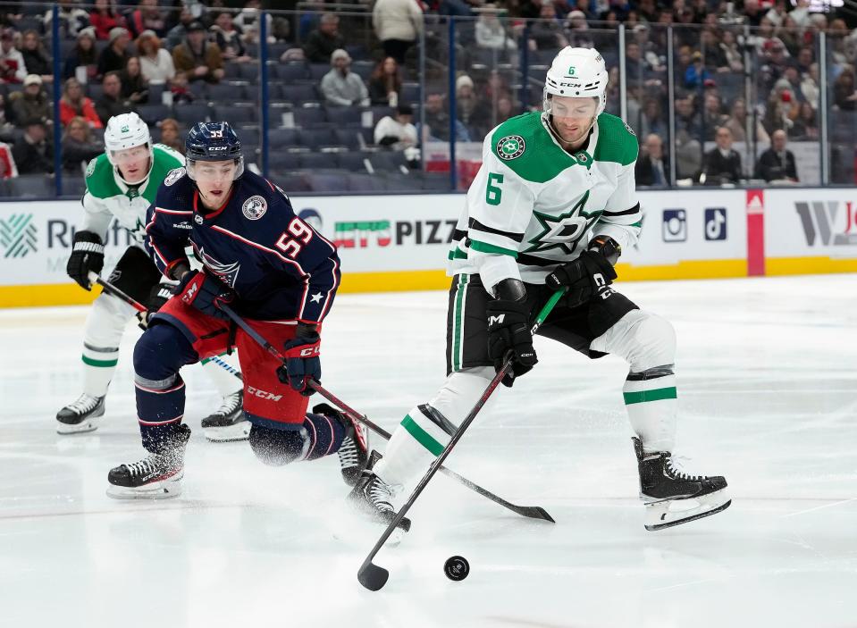Dec 19, 2022; Columbus, Ohio, USA; Columbus Blue Jackets right wing Yegor Chinakhov (59) tries to get the puck from Dallas Stars defenseman Colin Miller (6) during the first period of their NHL game at Nationwide Arena.