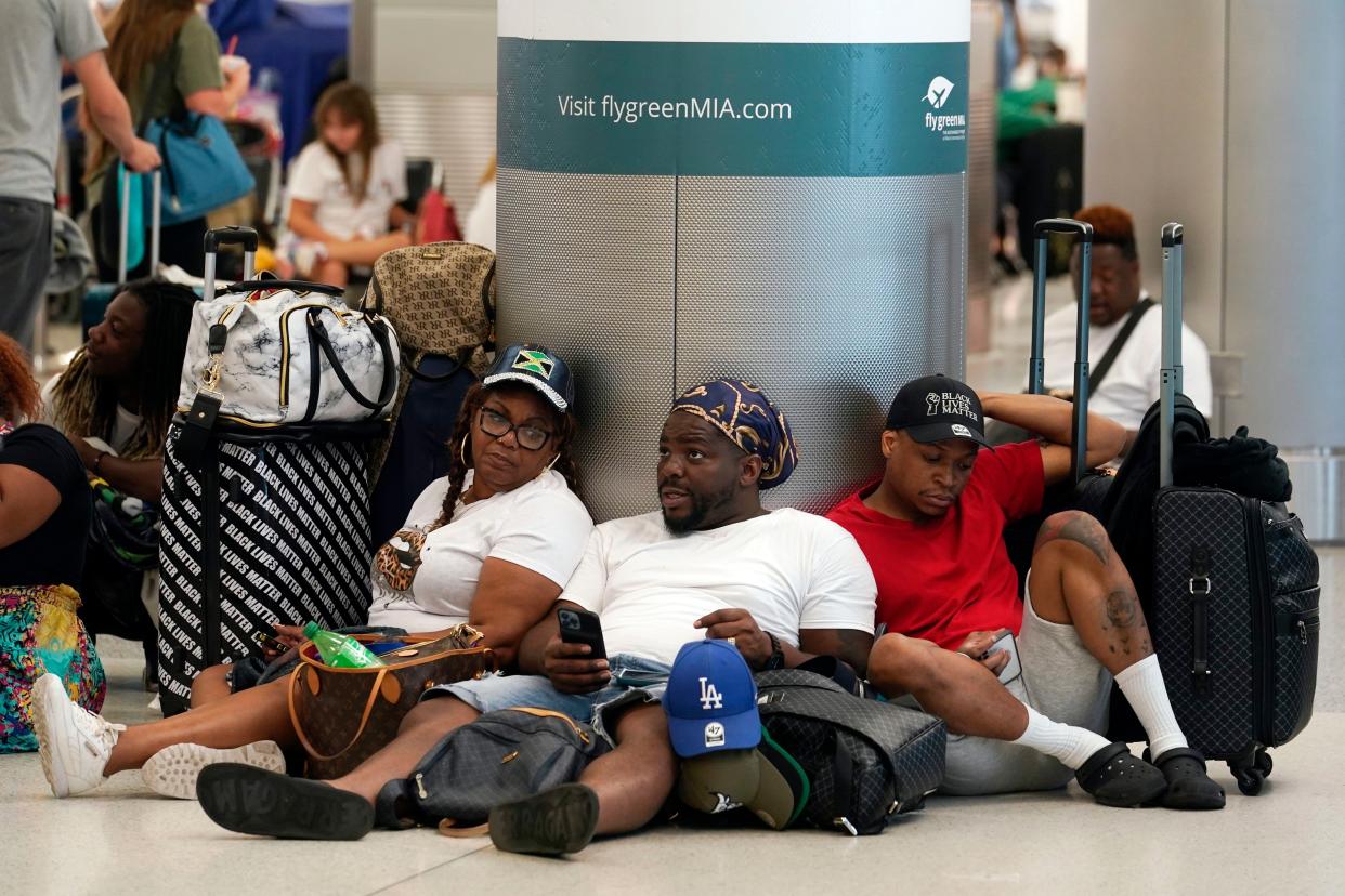 Alisson Bryan, Marcel Bryan and Terry Craig wait to check-in their luggage for their flight home to Missouri at Miami International Airport on Saturday.