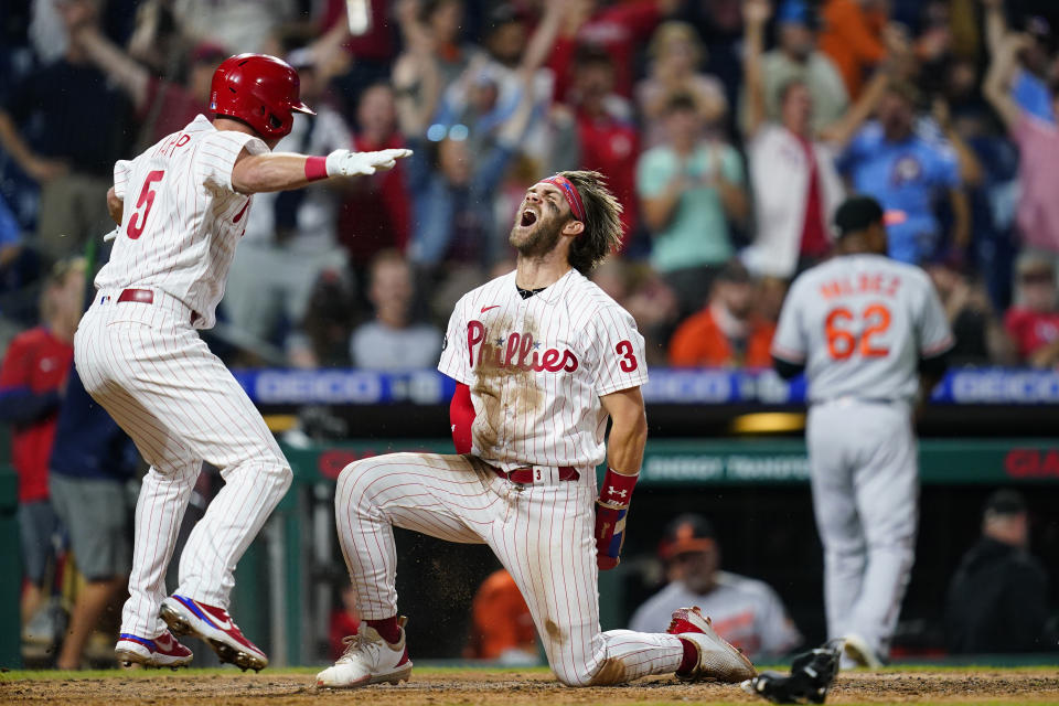 FILE - In this Sept. 21, 2021, file photo, Philadelphia Phillies' Bryce Harper (3) and Andrew Knapp (5) celebrate after Harper scored the game-winning run on a two-run triple by J.T. Realmuto during the 10th inning of an interleague baseball game against the Baltimore Orioles in Philadelphia. Harper has carried the Philadelphia Phillies into the NL East race. (AP Photo/Matt Slocum, File)