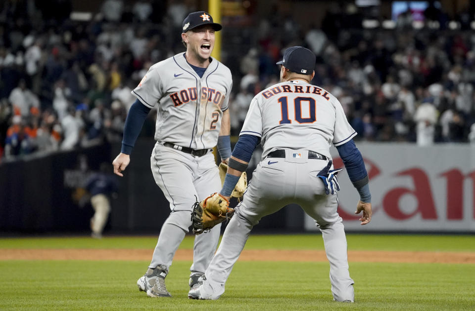 El tercera base Alex Bregman (2) y el primera base cubano Yuli Gurriel (10), de los Astros de Houston, festejan tras superar a los Yanquis de Nueva York 6-5 y barrer la serie de campeonato de la Liga Americana, el lunes 24 de octubre de 2022, en Nueva York. (AP Foto/John Minchillo)