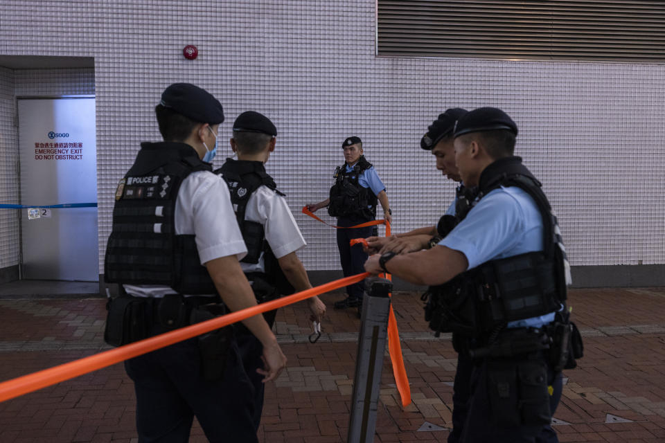 Police officers set up a cordon off area to conduct a search on members of the public in the Causeway Bay area on the eve of the 34th anniversary of China's Tiananmen Square massacre, in Hong Kong, Saturday, June 3, 2023. (AP Photo/Louise Delmotte)