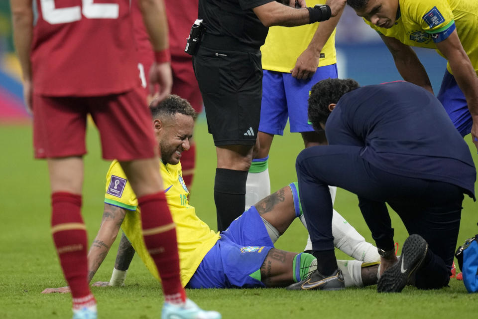 El delantero brasileño Neymar recibe tratamiento durante el partido contra Serbia por el Grupo G del Mundial, el jueves 24 de noviembre, en Lusail, Qatar. (AP Foto/Andre Penner)