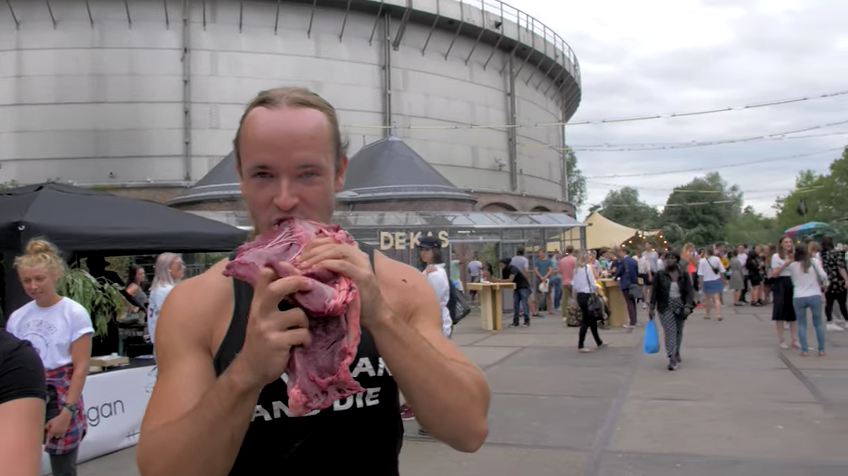 An <span>anti-vegan YouTuber named sv3rige eats a veal heart in front of a vegan festival in Amsterdam. </span>(Photo: YouTube)