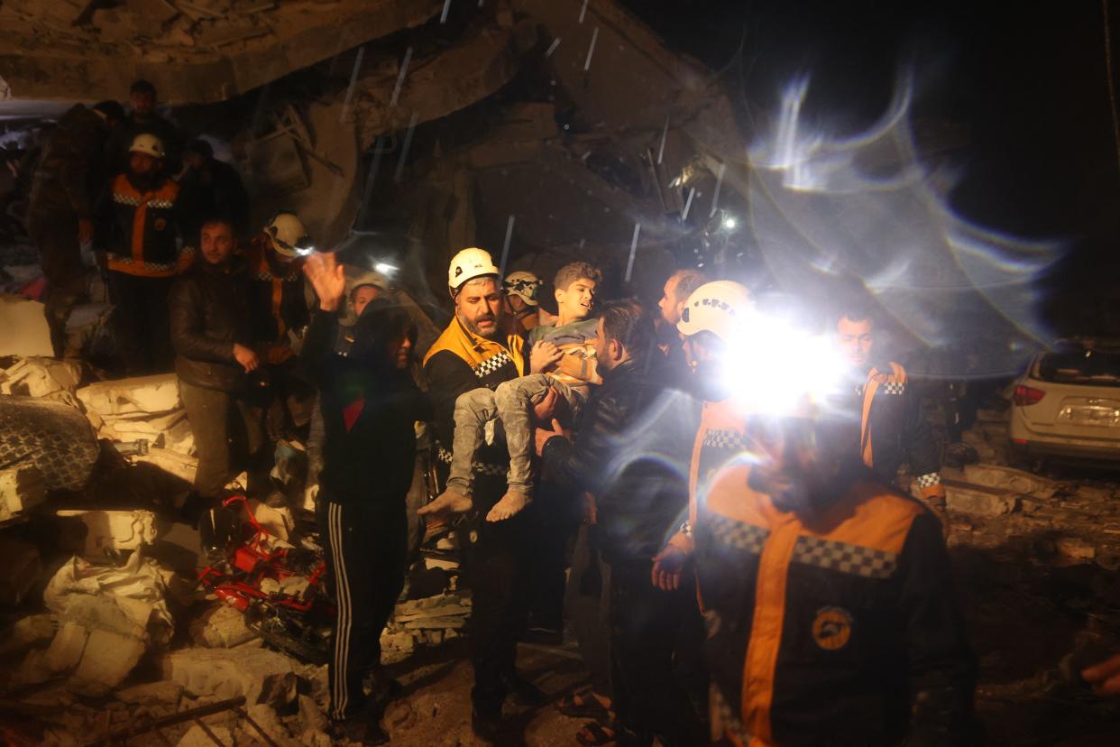 Rescue workers carry a boy they recovered from the rubble of a building after an earthquake in Dana, rebel-held Idlib, early on February 6, 2023. (Aaref Watad/AFP via Getty Images)