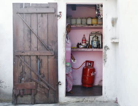 Munesh Nagar, a housewife, cooks on a stove using a Liquefied Petroleum Gas (LPG) cylinder in her kitchen at Dujana village in Noida, on the outskirts of New Delhi October 7, 2015. REUTERS/Anindito Mukherjee