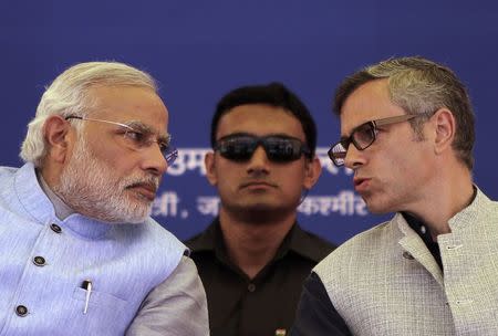 Kashmir's Chief Minister Omar Abdullah (R) speaks with Prime Minister Narendra Modi (L) as a security personnel watches after the inauguration ceremony of a train on a new stretch of railway to the town of Katra, northwest of Jammu July 4, 2014. REUTERS/Mukesh Gupta