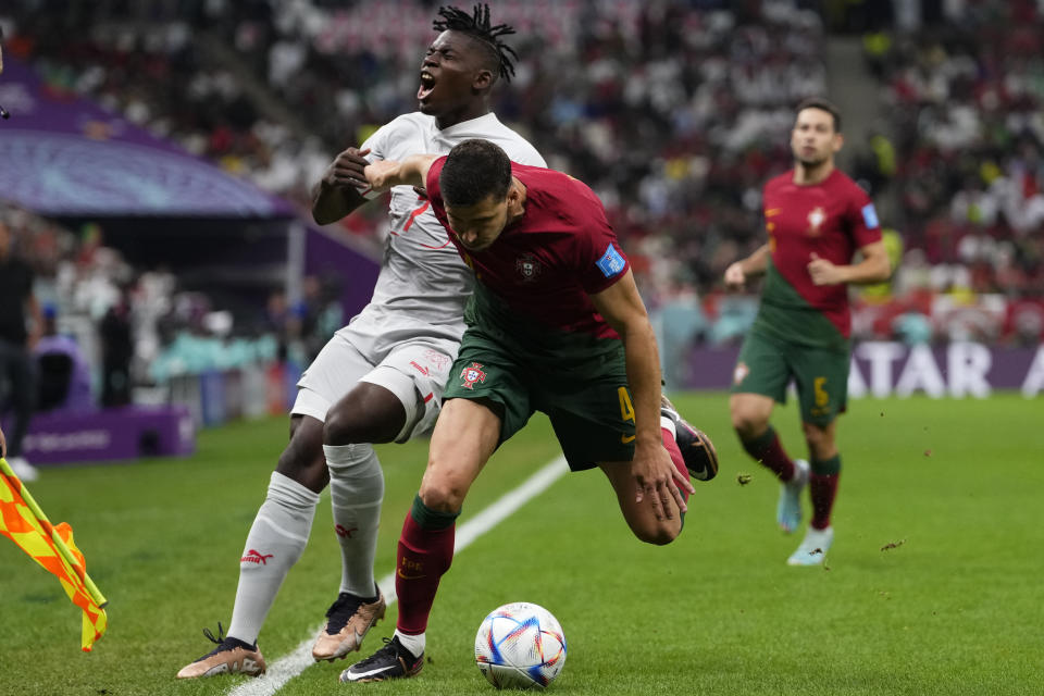 Switzerland's Breel Embolo, left, and Portugal's Ruben Dias battle for the ball during the World Cup round of 16 soccer match between Portugal and Switzerland, at the Lusail Stadium in Lusail, Qatar, Tuesday, Dec. 6, 2022. (AP Photo/Manu Fernandez)