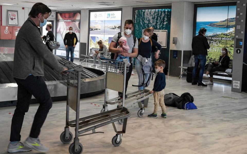 Tourists wait for their luggage in Crete - AFP