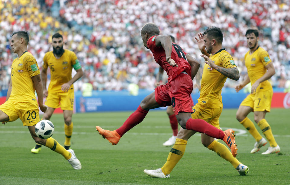 <p>Christian Cueva kicks the ball under pressure from the Australian defence </p>