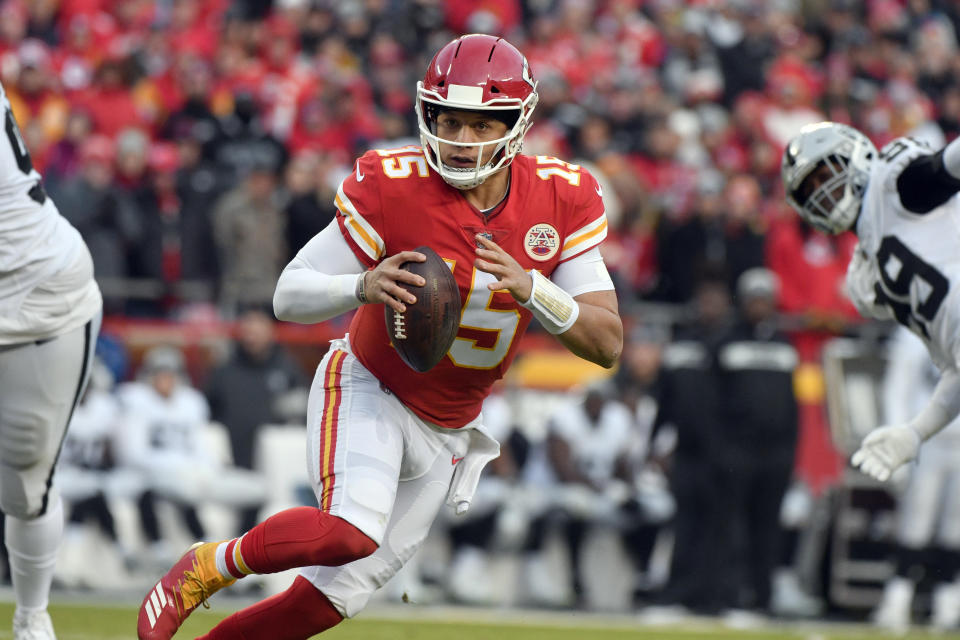 Kansas City Chiefs quarterback Patrick Mahomes (15) scrambles between Oakland Raiders defensive tackle Johnathan Hankins (90) and defensive end Arden Key (99) during the first half of an NFL football game in Kansas City, Mo., Sunday, Dec. 30, 2018. (AP Photo/Ed Zurga)