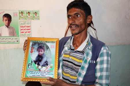 Abdullah al-Khawlani holds a picture of his son, Waleed, who was killed by last month's Saudi-led air strike that killed dozens including children in Saada, Yemen September 4, 2018. Picture taken September 4, 2018. REUTERS/Naif Rahma