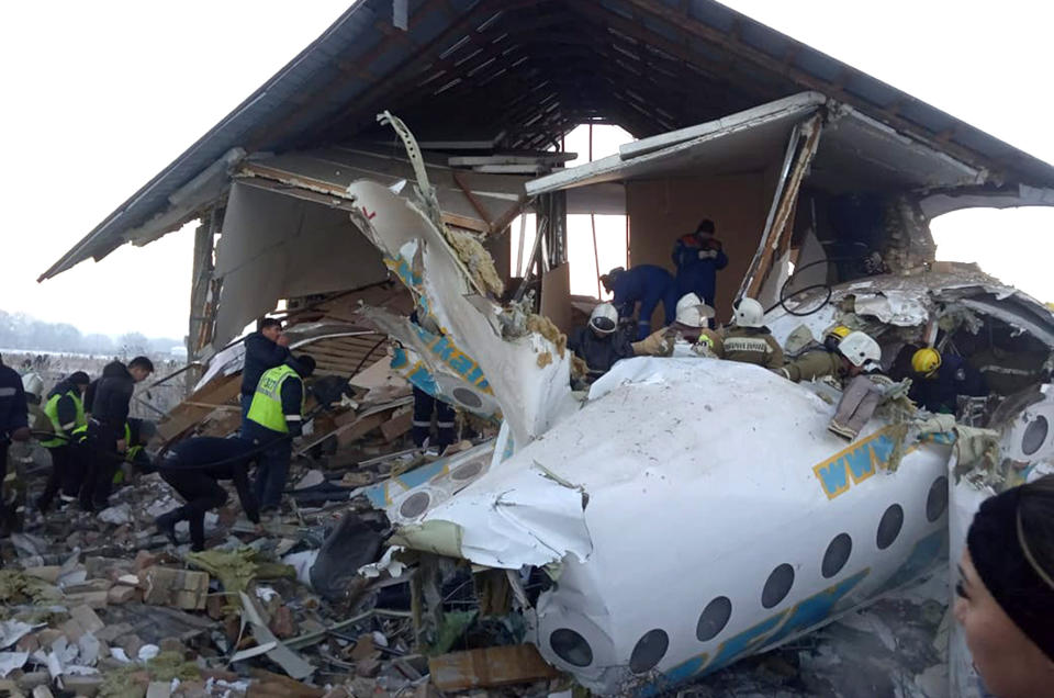 In this handout photo provided by the Emergency Situations Ministry of the Republic of Kazakhstan, police and rescuers work on the side of a plane crash near Almaty International Airport, outside Almaty, Kazakhstan, Friday, Dec. 27, 2019. Almaty International Airport said a Bek Air plane crashed Friday in Kazakhstan shortly after takeoff causing numerous deaths. The aircraft had 100 passengers and crew onboard when hit a concrete fence and a two-story building shortly after takeoff. ( Emergency Situations Ministry of the Republic of Kazakhstan photo via AP)