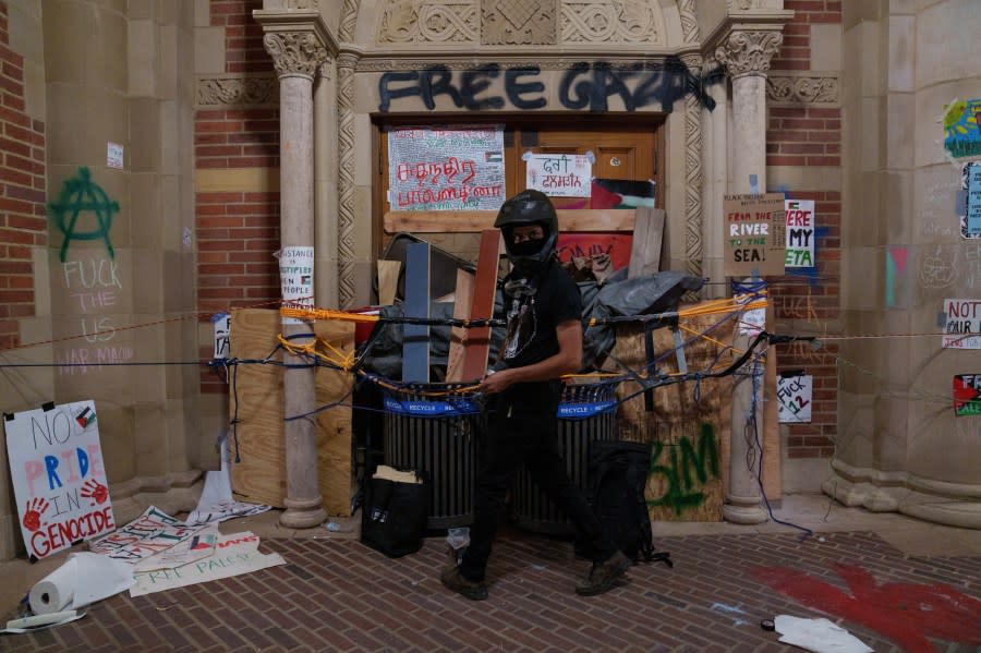 LOS ANGELES, CALIFORNIA – MAY 2: A Pro-Palestinian protestor barricades a door in an encampment at the University of California, Los Angeles (UCLA) campus on May 2, 2024 in Los Angeles, California. The camp was declared ‘unlawful’ by the university and many protestors have been detained. Pro-Palestinian encampments have sprung up at college campuses around the country with some protestors calling for schools to divest from Israeli interests amid the ongoing war in Gaza. (Photo by Eric Thayer/Getty Images)LOS ANGELES, CALIFORNIA – MAY 2: <> on May 1, 2024 in Los Angeles, California. (Photo by Eric Thayer/Getty Images)