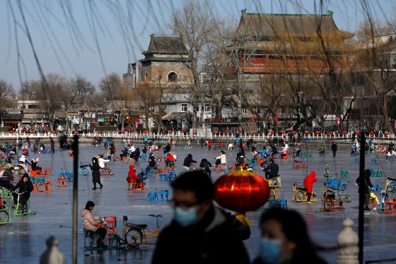 People wearing face masks following the coronavirus disease (COVID-19) outbreak skate on a frozen lake