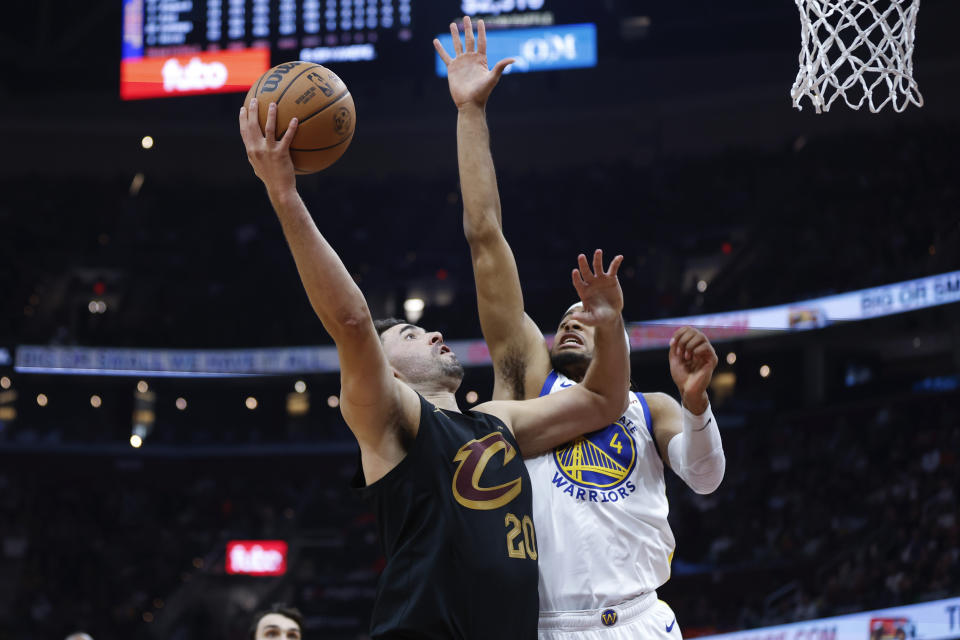 Cleveland Cavaliers forward Georges Niang (20) shoots against Golden State Warriors guard Moses Moody (4) during the first half of an NBA basketball game, Sunday, Nov. 5, 2023, in Cleveland. (AP Photo/Ron Schwane)