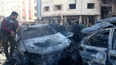 Residents and soldiers loyal to Syria's President Bashar al-Assad inspect damage after a suicide attack in Sayeda Zeinab, a district of southern Damascus, Syria January 31, 2016. REUTERS/Stringer