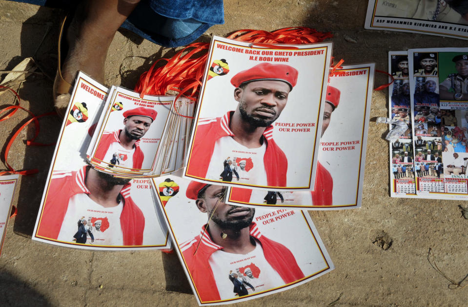 FILE - In this Thursday, Sept. 20, 2018 file photo, a supporter sits by posters of pop star-turned-opposition lawmaker Bobi Wine, whose real name is Kyagulanyi Ssentamu, at his home in Kampala, Uganda. Wine staged his first concert Saturday, Nov. 10, 2018 since being charged with treason, in a show of defiance punctuated by anti-government slogans and barbs aimed at the long-time president he is challenging. (AP Photo/Ronald Kabuubi, File)