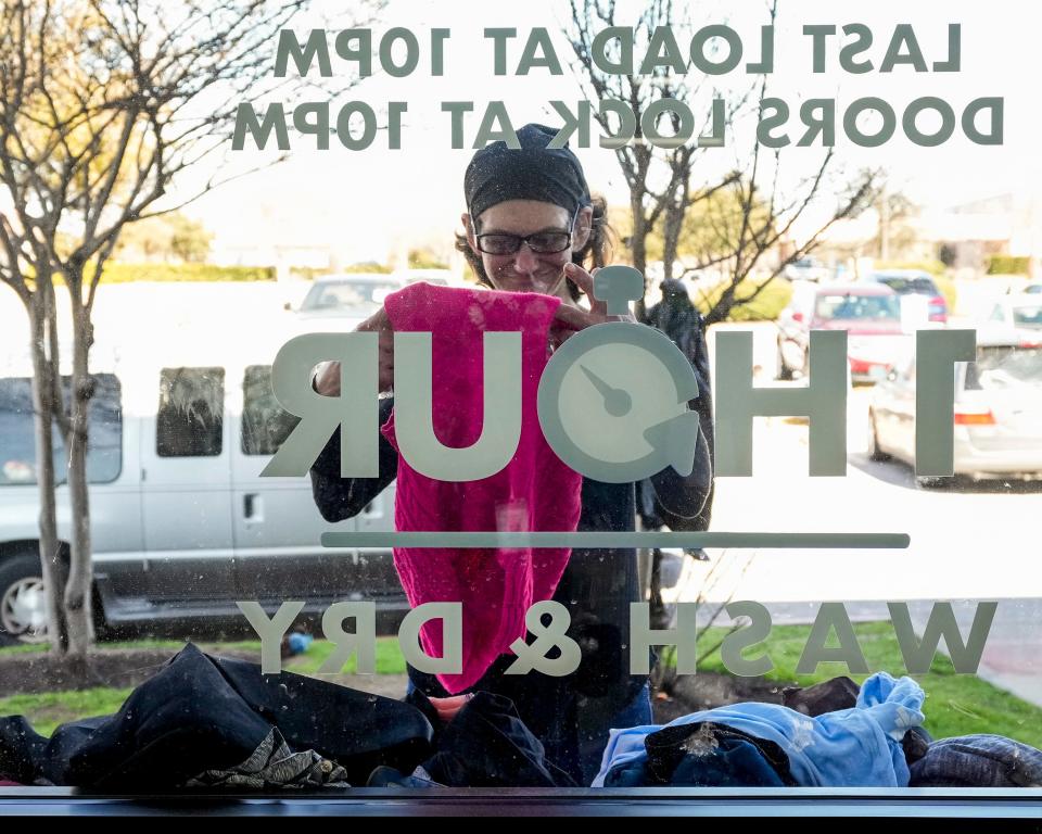 Bee Sykes looks at donated clothing from Kerby’s Clothing Ministries at the Clean Laundry laundromat last week.