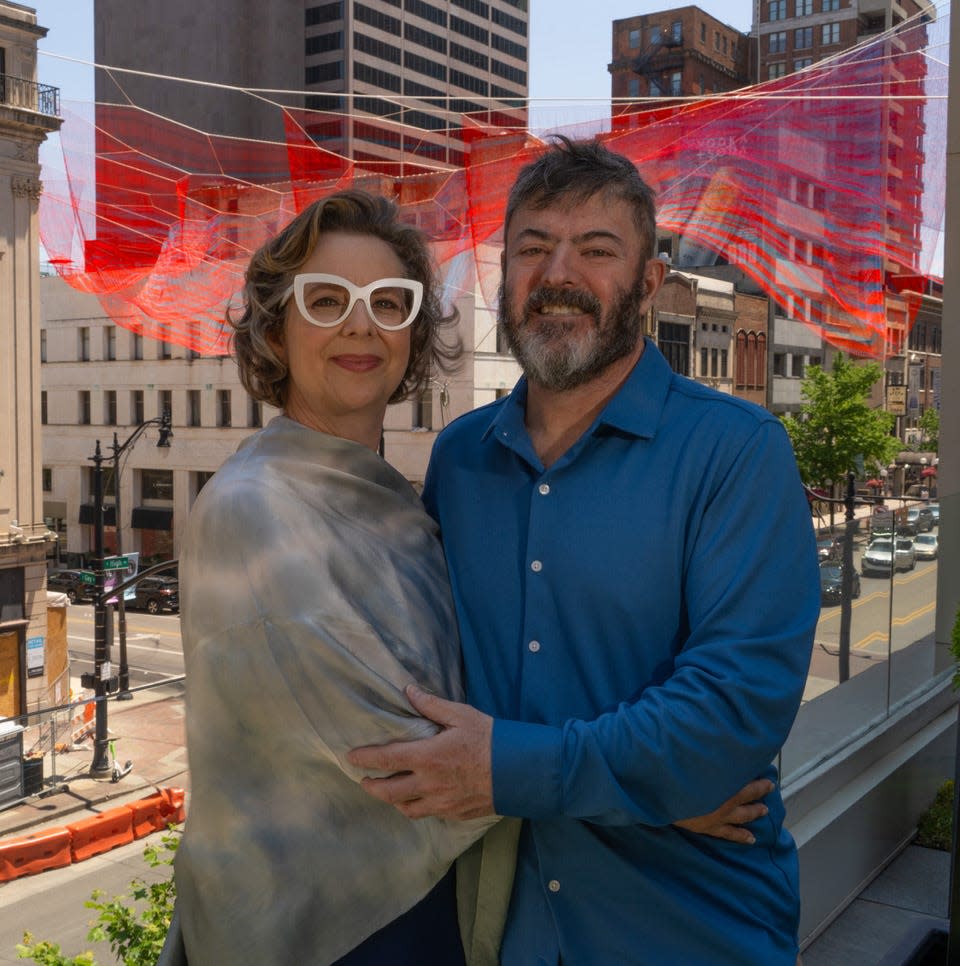 Artist Janet Echelman stands with her husband and technologist, David Feldman, in front of "Current," the recently installed artwork above the intersection of Gay and High streets.