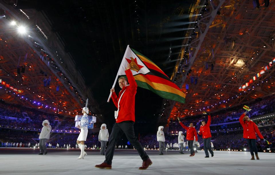 Zimbabwe's flag-bearer Luke Steyn waves as he leads his country's contingent during the opening ceremony of the 2014 Sochi Winter Olympic Games February 7, 2014. REUTERS/Brian Snyder (RUSSIA - Tags: SPORT OLYMPICS)