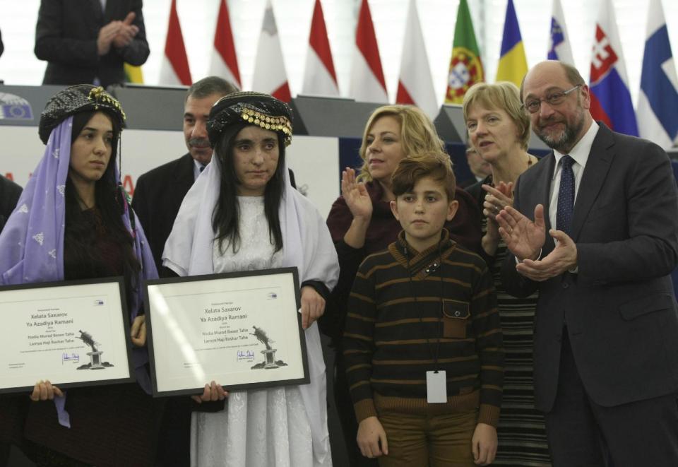 Yazidi women from Iraq, Nadia Murad Basee, left, and Lamiya Aji Bashar, 2nd left, pose with their award while Bashar's brother Vad looks on after receiving the European Union's Sakharov Prize for human rights from the hands of European Parliament President Martin Schulz, right, at the European Parliament in Strasbourg, eastern France, Tuesday Dec. 13, 2016. Two Yazidi women who escaped sexual enslavement by the Islamic State group and went on to become advocates for others have won the European Union's Sakharov Prize for human rights. The award, named after Soviet dissident Andrei Sakharov, was created in 1988 to honor individuals or groups who defend human rights and fundamental freedoms. (AP Photo/Christian Lutz)