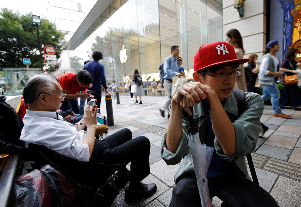 Masashi Miyaji (R) reacts after he is told that Apple's new iPhone 7 in the new jet black colour has sold out by Apple store staff, as he waits for the release of new products in front of the Apple Store, in Tokyo's Omotesando shopping district, Japan September 15, 2016. REUTERS/Toru Hanai