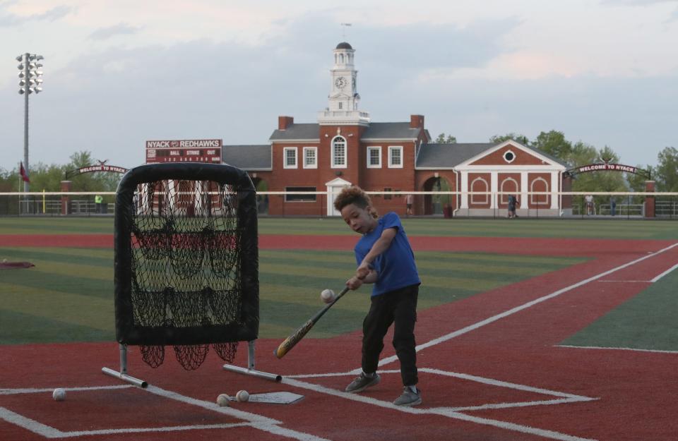 Hudson Rodriguez-Page, 7, practices his batting at Nyack High School in Upper Nyack May 8, 2024. The building in right field also overlooks the football field below and is reminiscent of the old Nyack High School.