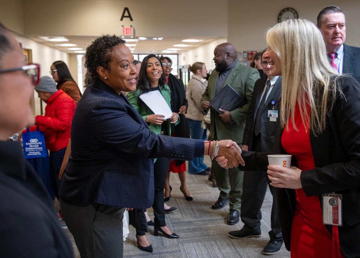 Kimberly McClain, assistant secretary at the U.S. Department of Housing and Urban Development, greets Fitchburg Mayor San Squailia during an event at the Community Health Connection in Leominster.