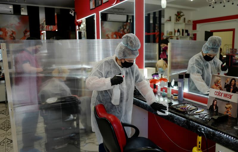 A worker wearing a protective mask and gloves cleans in a hair salon on the first day of the reopening following loosened lockdown restrictions amid the coronavirus disease (COVID-19) outbreak in Kaliningrad