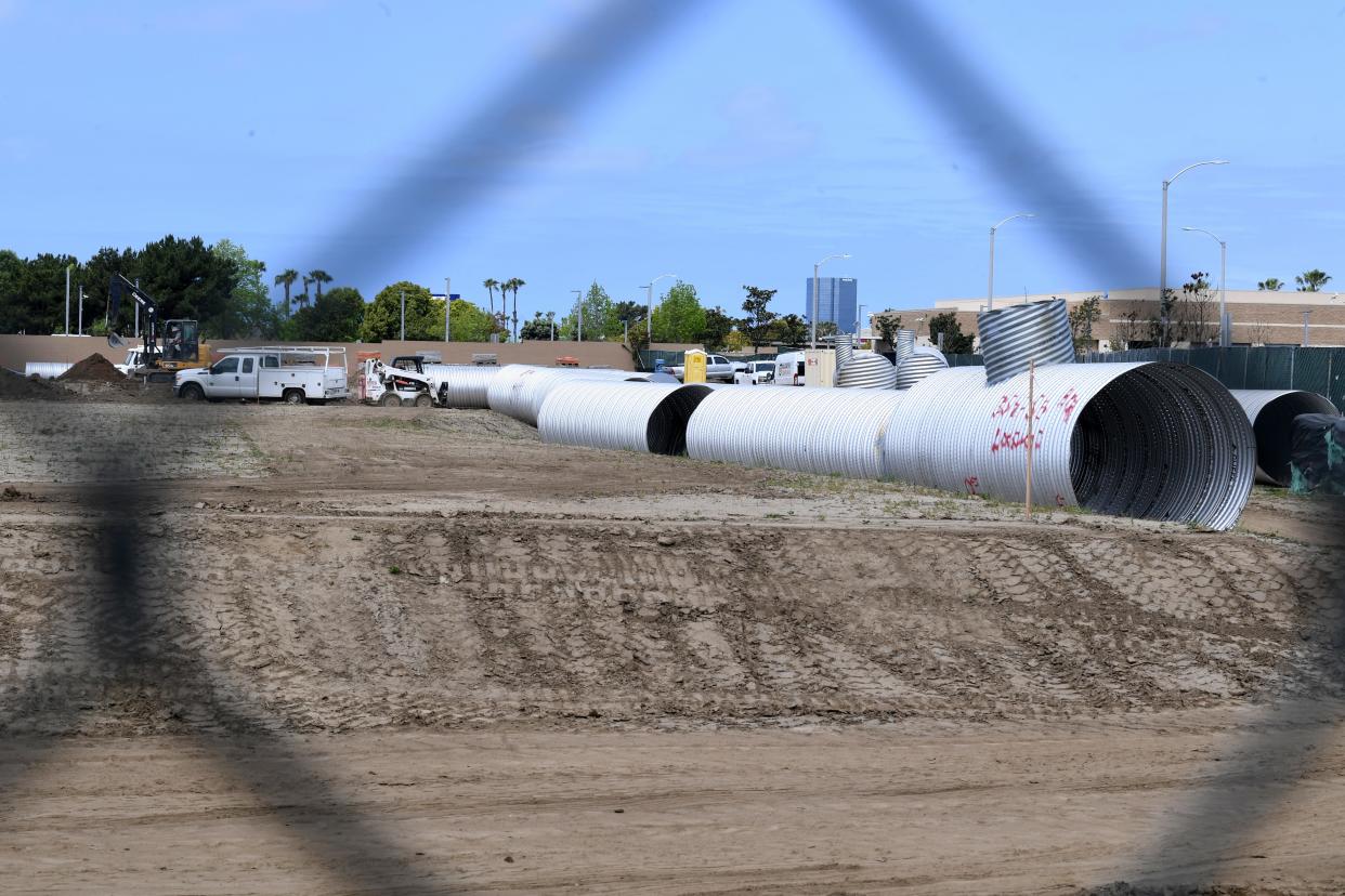 Construction activity is visible behind a chain-link fence Tuesday as work begins on 341 affordable apartment for seniors 55 and over on Outlet Center Drive in Oxnard.