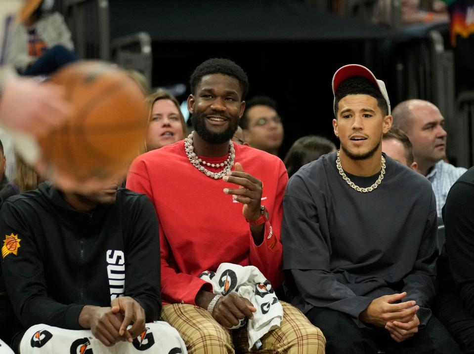 Apr 10, 2022; Phoenix, Ariz. U.S.;  Phoenix Suns center Deandre Ayton (left) and guard Devin Booker watch their team play against the Sacramento Kings during the second quarter at Footprint Center. They were held out of the game.