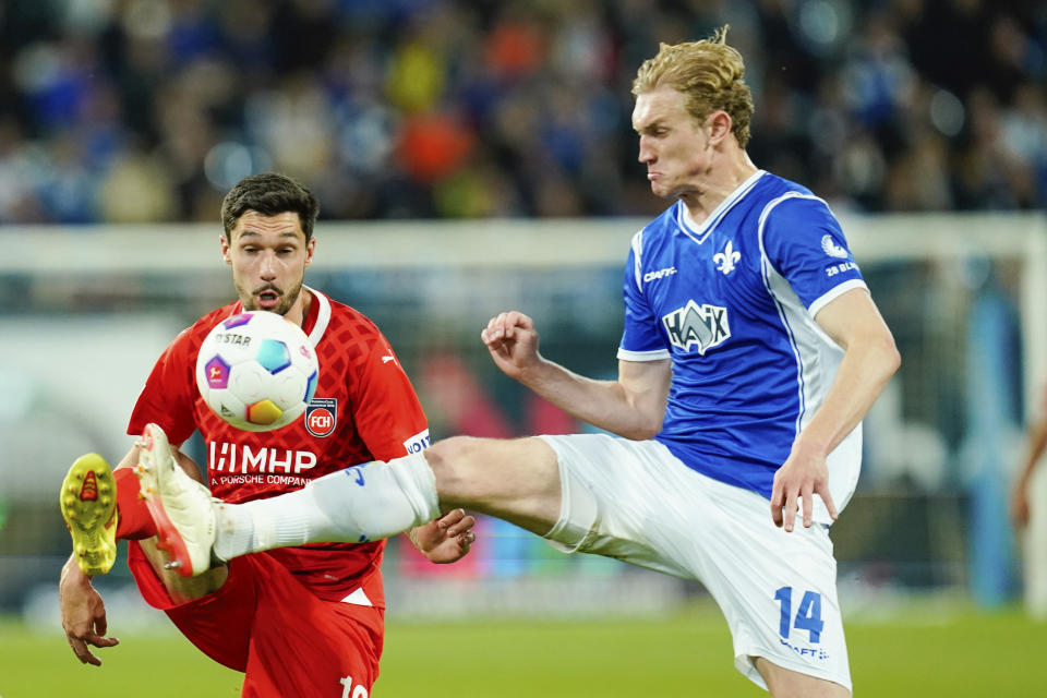 Heidenheim's Tim Kleindienst, left, and Darmstadt's Christoph Klarer battle for the ball during the Bundesliga soccer match between SV Darmstadt 98 and 1. FC Heidenheim in Darmstadt, Germany, Sunday April 28, 2024. (Uwe Anspach/dpa via AP)