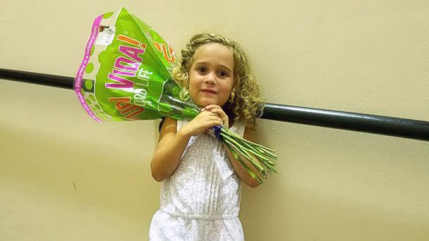 PHOTO: Little Sophia, 4, celebrates with flowers after her extremely passionate performance at her graduation ceremony. (Courtesy of Michelle Neshin)