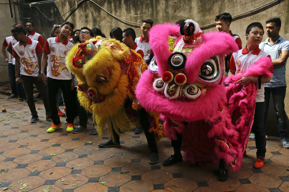 Indian ethnic Chinese boys wait to perform a lion dance on the first day of Chinese lunar new year in Kolkata, India, Saturday, Jan. 28, 2017. Chinese around the world are celebrating this year's Year of the Rooster according to the Chinese zodiac calendar. (AP Photo/Bikas Das)