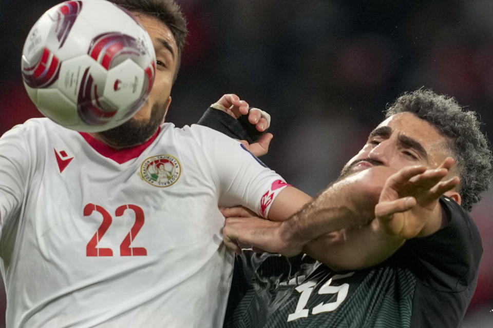 Tajikistan's Shahrom Samiev, left, duels for the ball with United Arab Emirates' Yahia Nader during the Asian Cup Round of 16 soccer match between Tajikistan and United Arab Emirates, at Ahmad Bin Ali Stadium, in Al Rayyan, Qatar, Sunday, Jan. 28, 2024. (AP Photo/Thanassis Stavrakis)