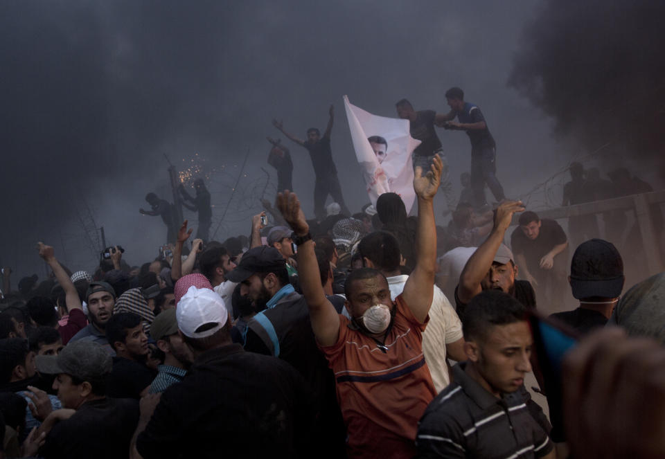Palestinians chant angry slogans as they cut the fence during a protest at the Gaza Strip's border with Israel, Friday, Oct. 5, 2018. (AP Photo/Khalil Hamra)