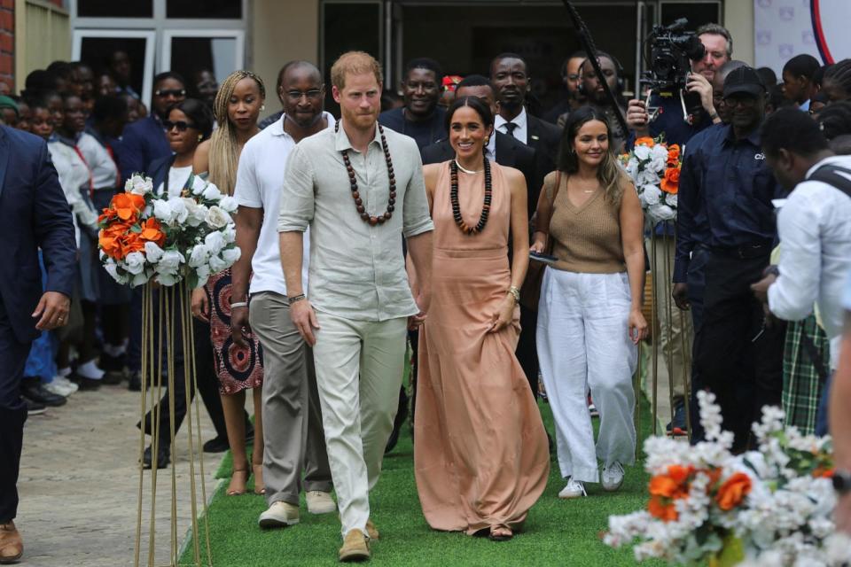 PHOTO:  Prince Harry, Duke of Sussex and his wife Meghan, Duchess of Sussex, walk out after meeting the students at the Lightway Academy in Abuja, Nigeria, May 10, 2024. (Akintunde Akinleye/Reuters)