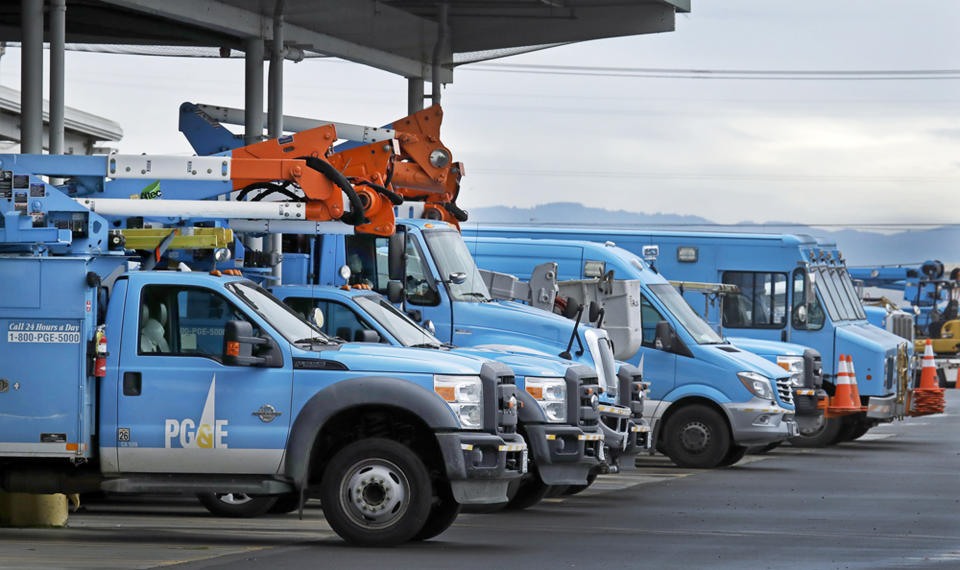 FILE - This Jan. 14, 2019, file photo shows Pacific Gas & Electric vehicles parked at the PG&E Oakland Service Center in Oakland, Calif. Pacific Gas & Electric Corp.'s top financial executives say they still haven't determined when the utility can start compensating victims of recent wildfires started by the utility's equipment. (AP Photo/Ben Margot, File)