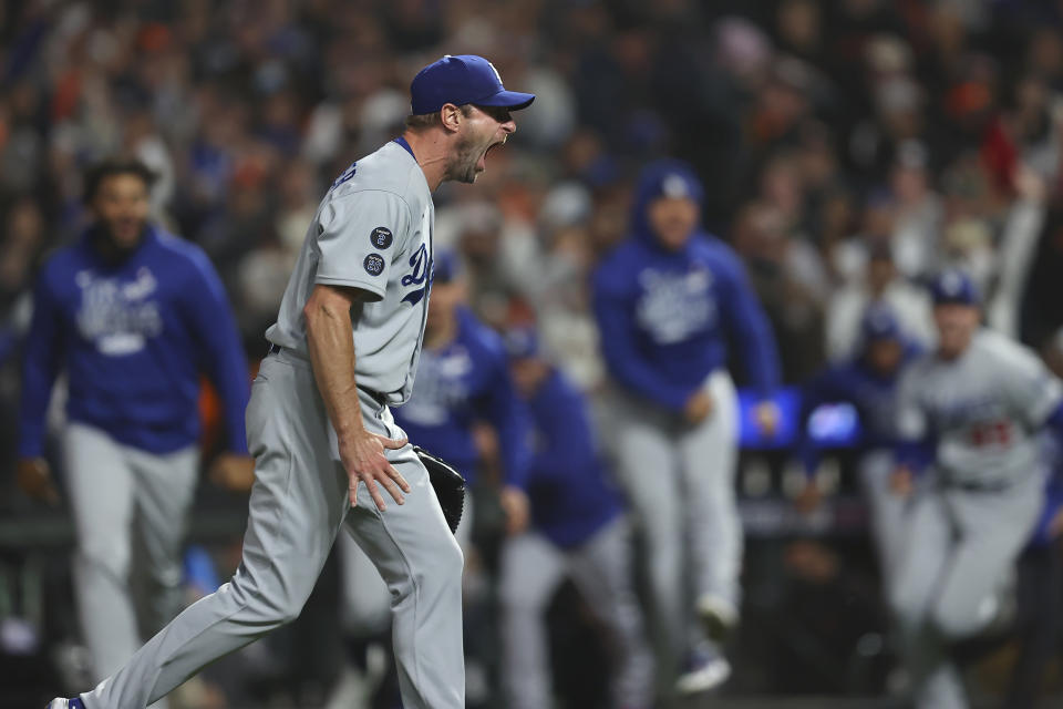 Los Angeles Dodgers pitcher Max Scherzer, foreground, celebrates with teammates after the Dodgers defeated the San Francisco Giants in Game 5 of a baseball National League Division Series Thursday, Oct. 14, 2021, in San Francisco. (AP Photo/John Hefti)