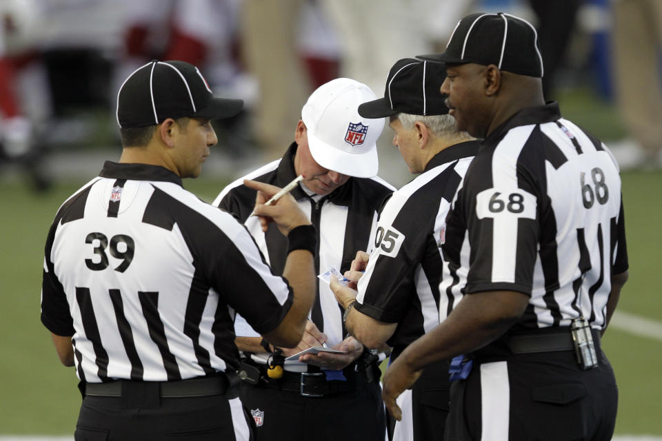 FILE - Referee Craig Ochoa, center, meets with Line Judge Esteban Garza (39), Field Judge Rusty Spindel (105) and Umpire Tim Morris (68) at the beginning of the first quarter of the Hall of Fame exhibition football game between the Arizona Cardinals and New Orleans Saints, Sunday, Aug. 5, 2012 in Canton. What can't be debated is the significance of the role officials have in each game. That's why, for one thing, teams prepare each week with an eye to who'll be carrying the yellow flags. (AP Photo/Gene J. Puskar, File)