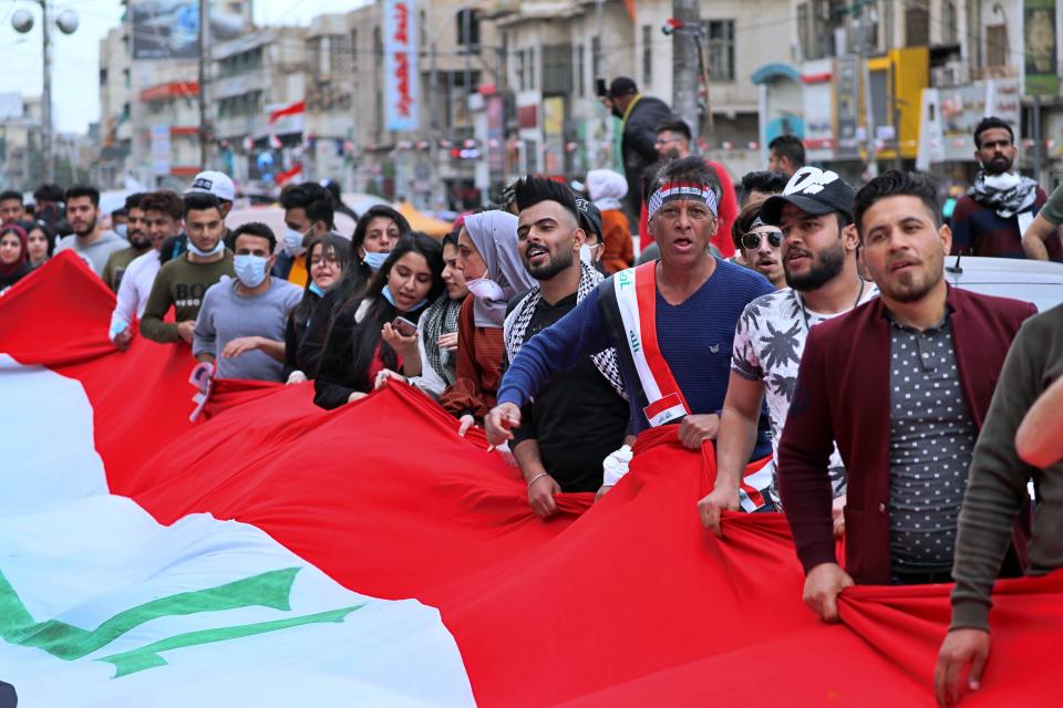 Anti-government protesters hold Iraqi flags during a rally in Baghdad, Iraq, Sunday, March 1, 2020. Iraqi student protesters converged on Baghdad's Tahrir Square, the epicenter of the five-month- anti-government protest movement, to voice their rejection of the country's proposed new prime minister. (AP Photo/Khalid Mohammed)