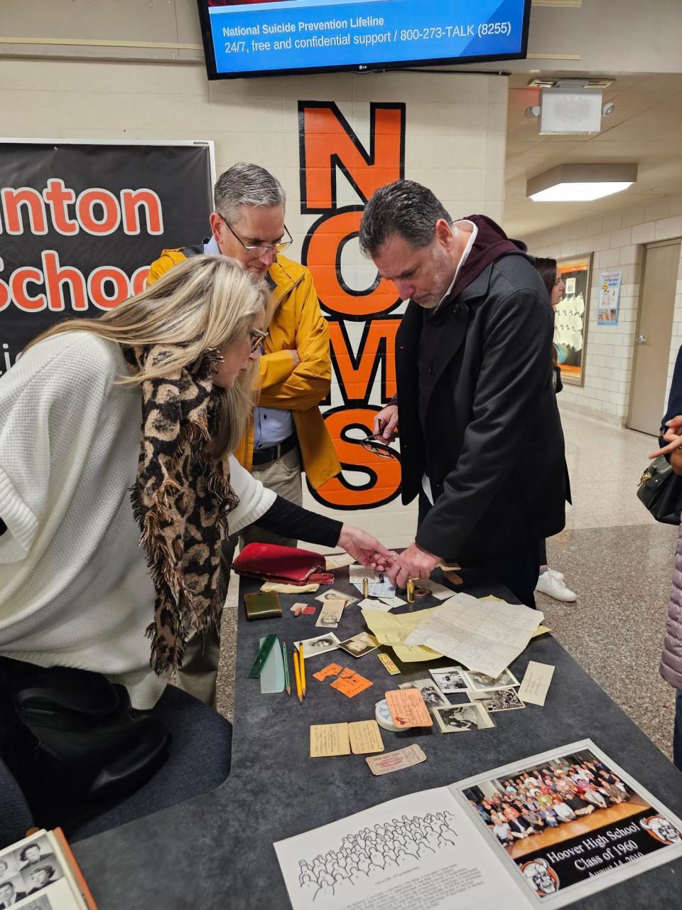 Siblings Charlotte Baron, from left, Emory Anderson and Charles Anderson look over black and white photos, newspaper clippings, membership cards and other items found in a purse owned by their mother Patti Rumfola. While a student at Hoover High School in the late 1950s, Rumfola's purse was lost between a wall and a set of lockers.