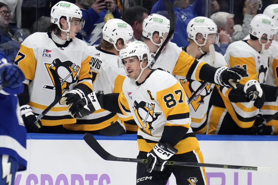 Pittsburgh Penguins center Sidney Crosby (87) celebrates with the bench after his goal against the Tampa Bay Lightning during the second period of an NHL hockey game Thursday, Nov. 30, 2023, in Tampa, Fla. (AP Photo/Chris O'Meara)