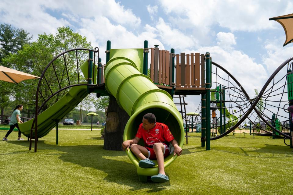 Joshua Towns jumps off the slide while playing on the new playground at Wesselman Park Thursday afternoon, April 18, 2024.