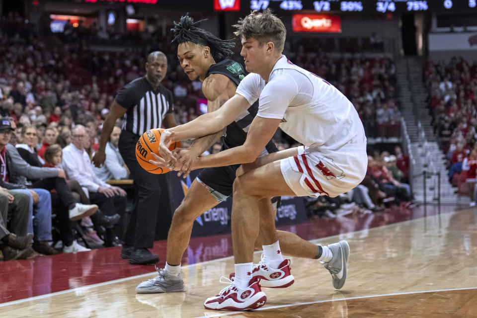 Chicago State's Noble Crawford, left, and Wisconsin's Nolan Winter (31) go after the ball during the first half of an NCAA college basketball game Friday, Dec. 22, 2023, in Madison, Wis. (AP Photo/Andy Manis)