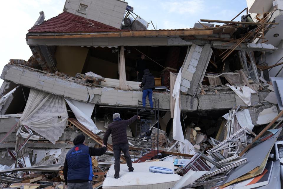 <p>A man stands inside a destroyed building as others react, in Iskenderun town, southern Turkey, Tuesday, Feb. 7, 2023. A powerful earthquake hit southeast Turkey and Syria early Monday, toppling hundreds of buildings and killing and injuring thousands of people. (AP Photo/Hussein Malla)</p> 